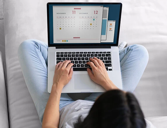 Young woman managing appointments on her laptop